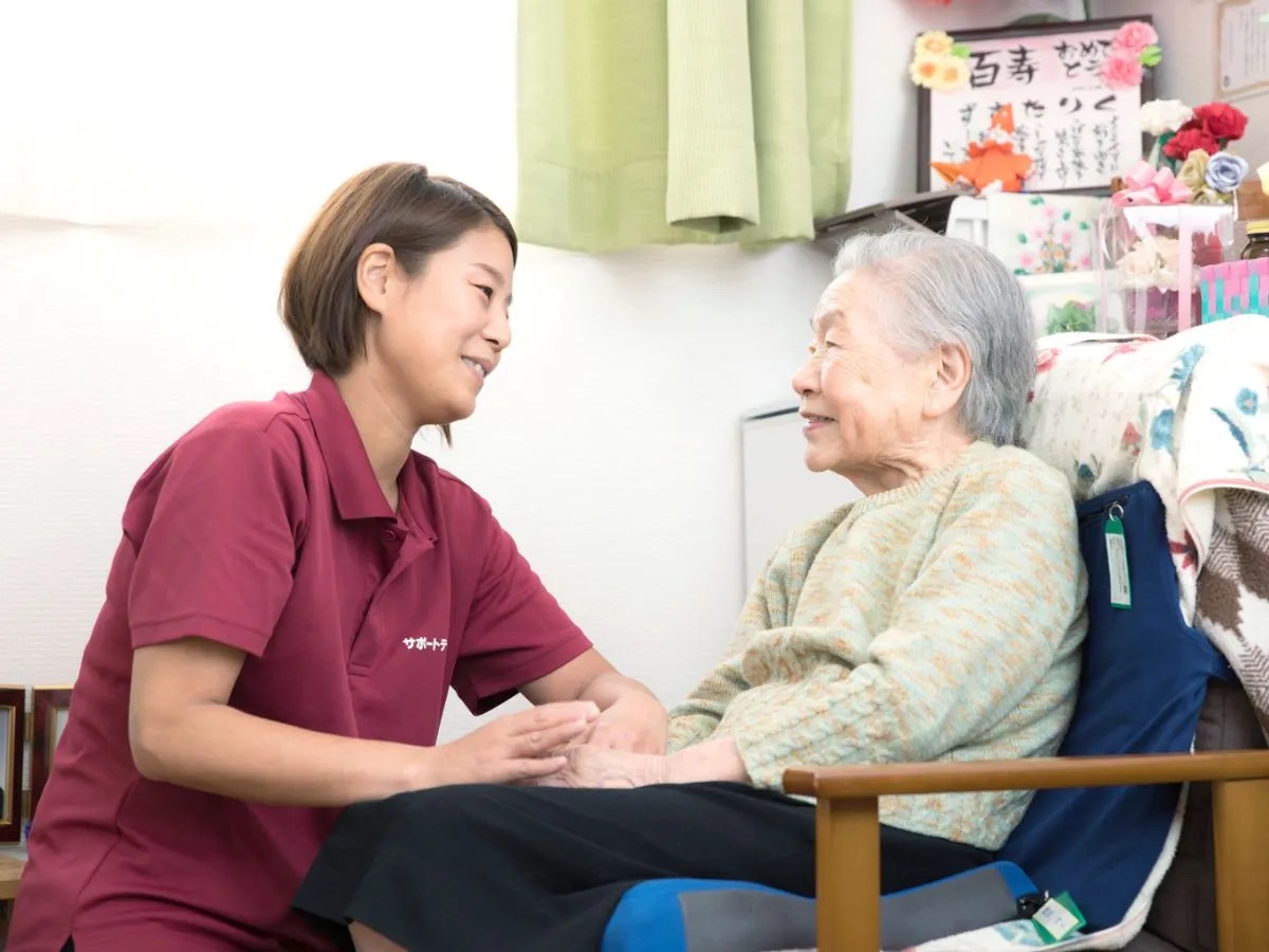 百寿のご利用者と笑顔で寄り添うスタッフ